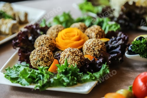 Preview: side view balls in sesame seeds on lettuce leaves with carrots in the form of a rose on a plate