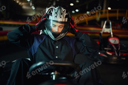 Preview: driver taking off helmet after racing in go kart car on circuit, speed drive and motorsport concept