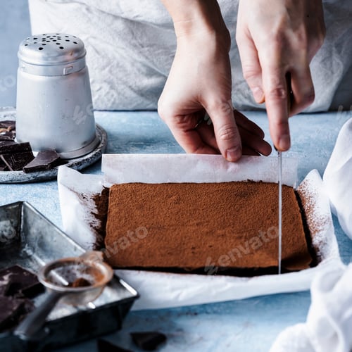 Preview: Woman cutting chocolate ganache truffle squares in the kitchen