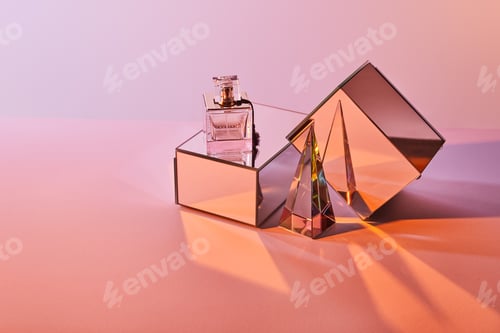 Preview: crystal transparent pyramid near perfume bottle and mirror cubes on pink background