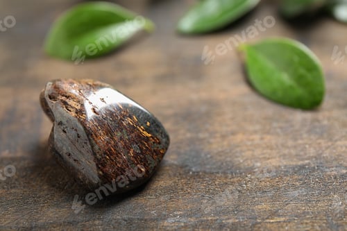Preview: Beautiful brown bronzite gemstone on wooden table