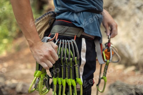 Preview: Shallow focus of a hiker adjusting his gear for climbing up a mountain in the countryside