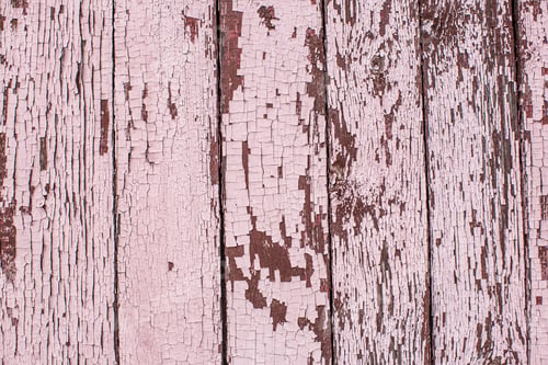 Preview: Old wooden planks painted with pink paint cracked by a rustic background
