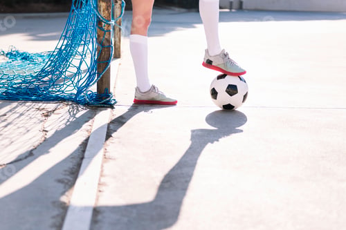 Preview: female football player stepping on a soccer ball