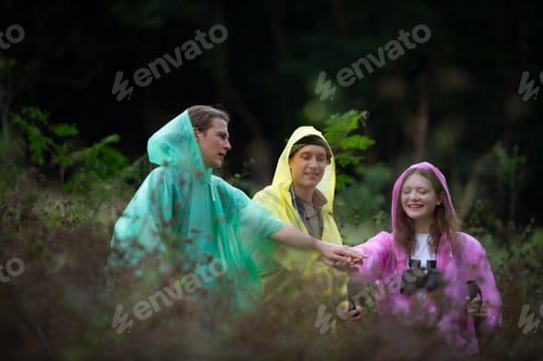 Preview: Group of friends in raincoats with backpacks on a hike in the forest, Prepare to hiking