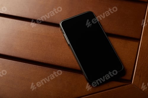 Preview: smartphone with blank screen and copy space on wooden table