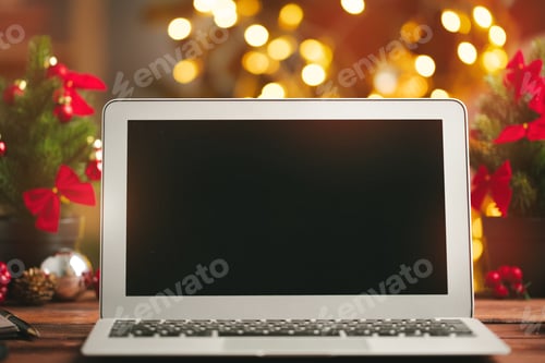 Preview: Wooden desk with computer with blank screen against blurred christmas lights background
