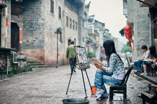 Preview: Artist capturing the essence of an old street on a rainy day.