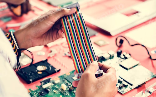 Preview: Clsoeup of hands holding computer breadboard flat wires cables
