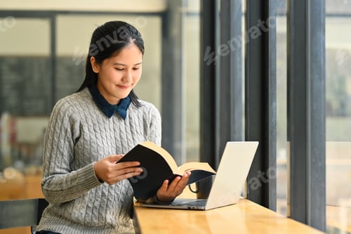Preview: Positive asian woman reading novel or checking his working schedule plan.