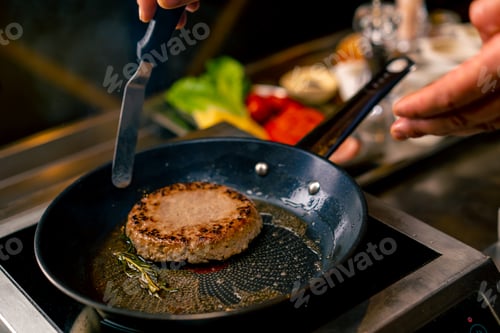 Preview: A close-up of a chef frying a beef patty for a burger in the kitchen of an Italian restaurant