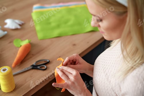 Preview: Top view of woman sewing Easter decorations