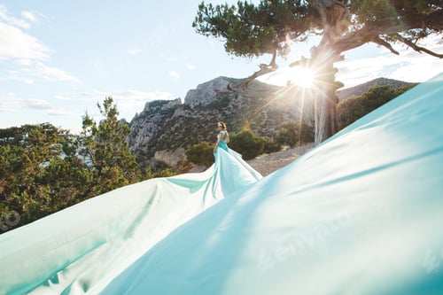 Preview: Bride in nature in the mountains near the water. The bride is playing with his dress.