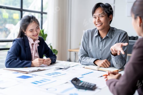 Preview: Marketing team discussing sales data with charts and graph on table in office