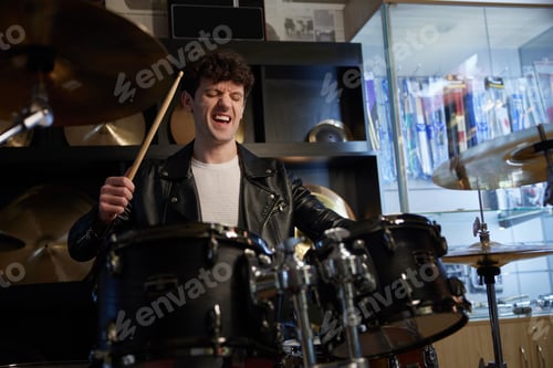 Preview: A man wearing a stylish leather jacket is energetically playing the drums