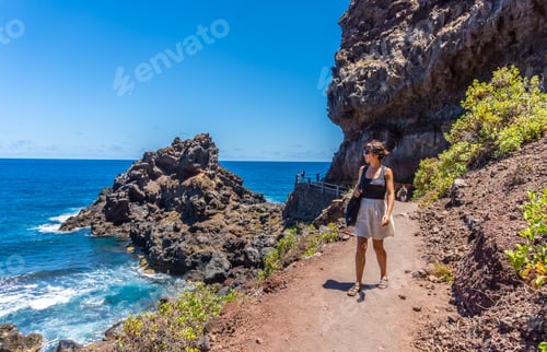Preview: A young woman walking along the path in summer to the beach of Nogales