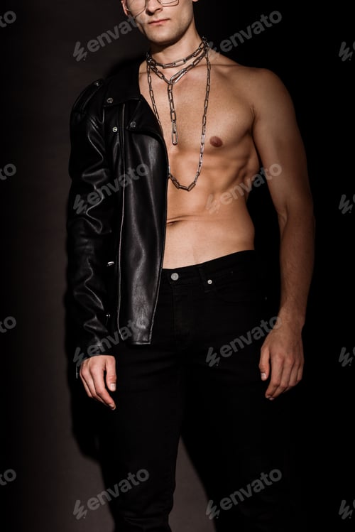 Preview: cropped view of muscular man with chains on neck standing on black