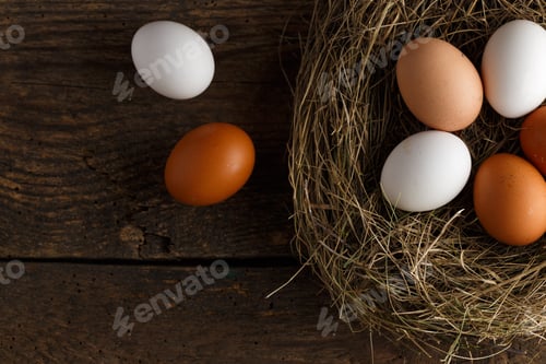 Preview: Chicken eggs in a nest on a wooden rustic background