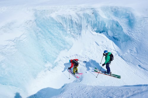 Aperçu: Two male skiers skiing down ravine on Mont Blanc massif, Graian Alps, France