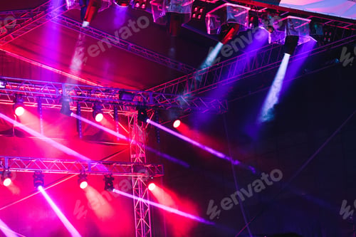Preview: Spotlights, red and blue beams of lights above stage during concert event festival