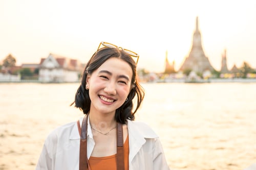 Preview: Young asian woman smiling at sunset in Bangkok