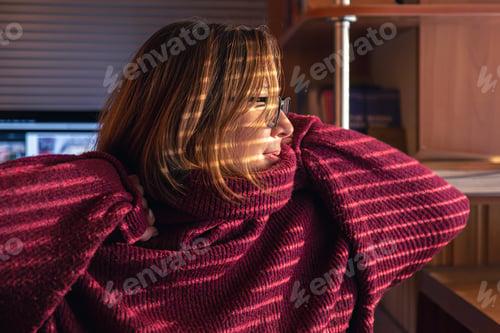 Preview: A woman looks through the blinds at the early morning sunlight.