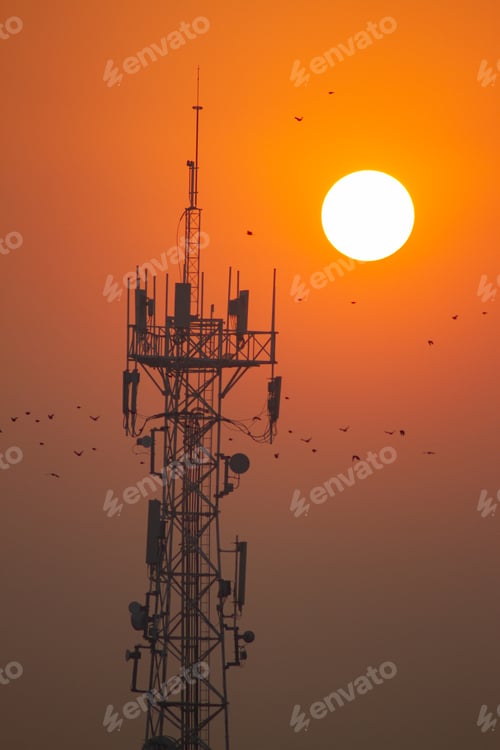 Preview: Sunrise illuminating a radio base station, with a bright sky in the background.