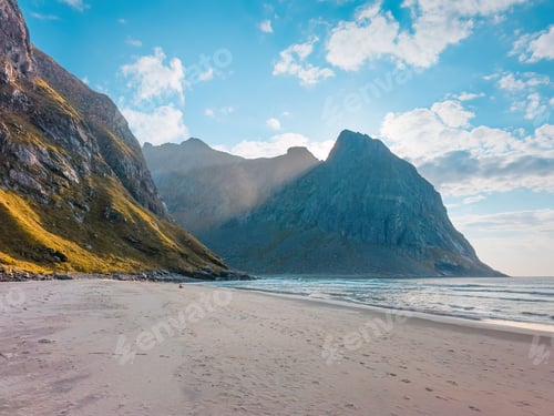 Preview: Scenic view of a serene beach with towering mountains under a vibrant blue sky in Lofoten, Norway