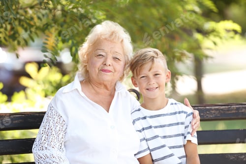 Preview: Elderly woman with grandson on bench in park