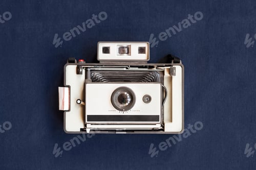 Preview: Top view of old instant camera on blue table