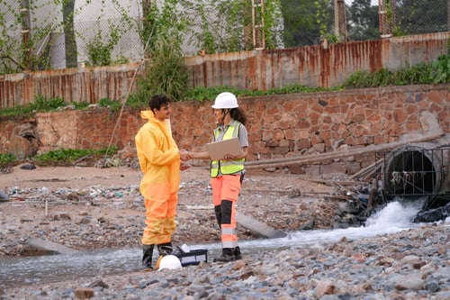 Preview: Two environmental researchers walk back from shoreline testing.