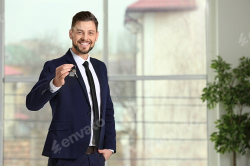 Preview: Real estate agent holding house key, indoors