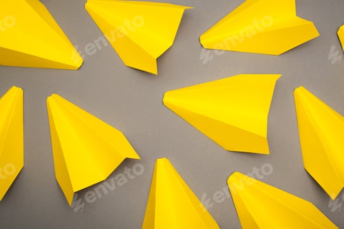 Preview: top view of yellow paper planes on grey background