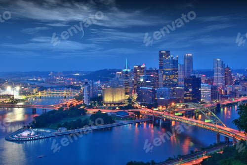 Preview: Aerial view of cityscape Pittsburgh surrounded by buildings and water in evening
