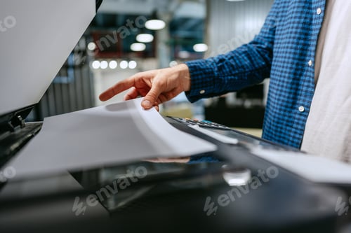 Preview: Person using a copier to scan documents in a modern office environment during the day