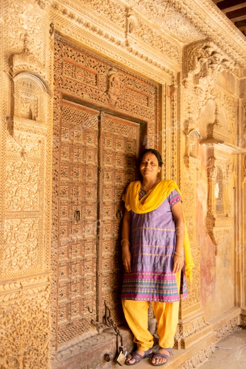Preview: Woman tourist in front of old wooden door, Jaisalmer, India