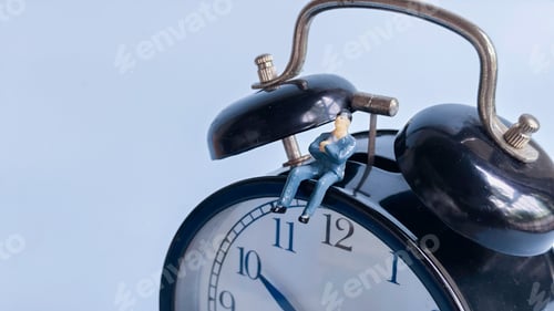 Preview: Miniature Businessman Sitting on an Alarm Clock