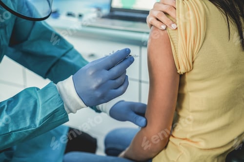 Preview: Doctor with hazmat suit and protective gloves giving patient a vaccine
