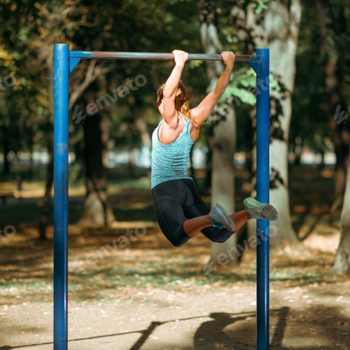 Preview: Woman Exercising on Horizontal Bar Outdoors in The Fall