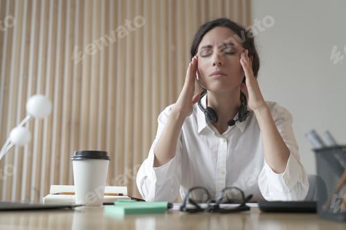 Preview: Frustrated Italian woman with closed eyes massaging temples, suffering from headache at work