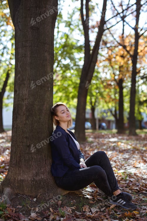 Preview: Vertical shot of a beautiful Caucasian female posing in a park