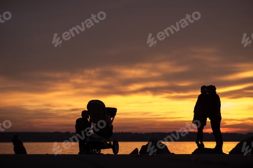Preview: Young family with a baby in a pushchair and kids