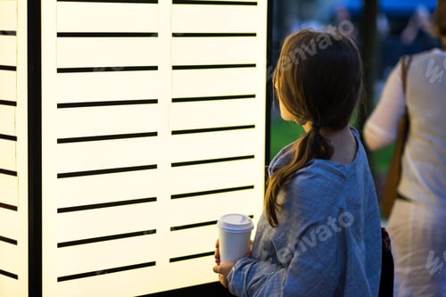 Preview: beautiful woman looking with interest on blank billboard deciding where to go