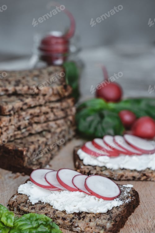 Preview: Fitness bread with cottage cheese, radish and basil on rustic wood background, closeup