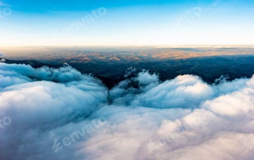 Preview: Thick layer of white clouds above mountains at sunrise