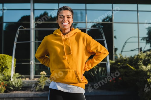 Preview: Happy African girl with cheerful smile having a break after jogging wearing sporty outfit