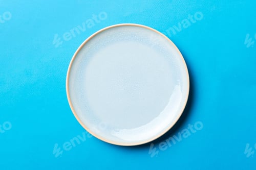 Preview: Top view of isolated of colored background empty round blue plate for food.