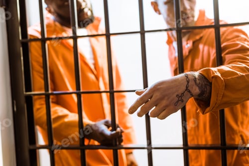 Preview: multicultural prisoners standing near prison bars in prison cell