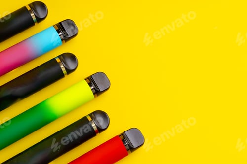 Preview: Colorful disposable electronic cigarettes on yellow background