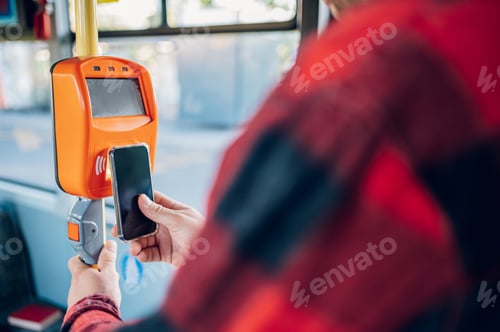 Preview: Close shot of a man hand holding a smartphone while paying a bus ticket